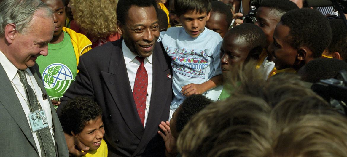 Embaixador da Boa Vontade da Conferência das Nações Unidas sobre Meio Ambiente e Desenvolvimento (UNCED), Pele (segurando crianças) do Brasil, é saudado por crianças enquanto se dirige para o Plenário no Rio de Janeiro, Brasil. (junho de 1992)