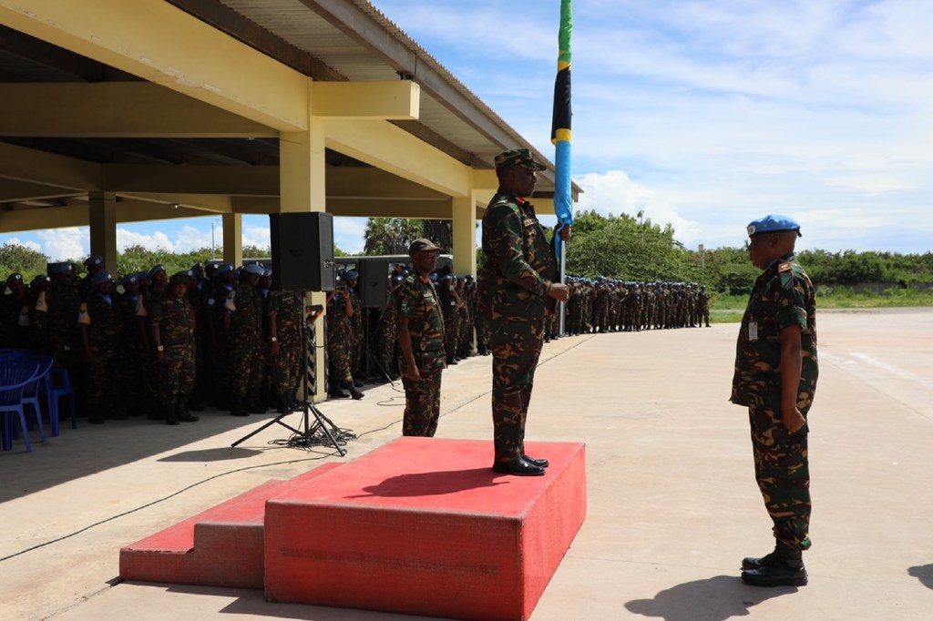 Kamanda wa TANBAT 7 akimkabidhi bendera Brigedia Jenerali George Mwita Itang'are wakati wa sherehe ya misheni ya kulinda amani UN .
