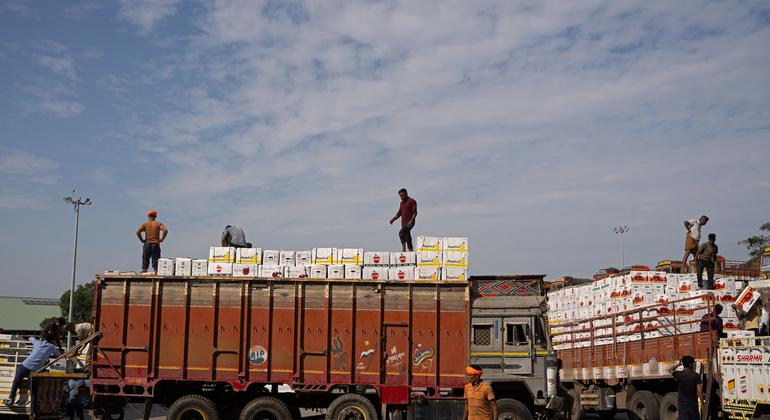 People are loading apples on trucks to sell. People are loading apples on trucks to sell.
