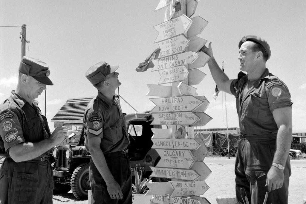 To remind them of home, UNEF personnel and members of the Royal Canadian Electrical and Mechanical Engineers built a signpost outside their workshop in Egypt, with various distances to cities in Canada. (file)