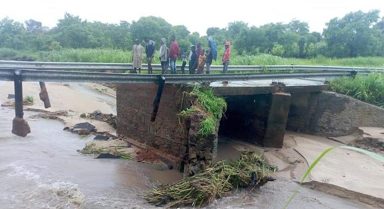 People stand on a damaged bridge in the aftermath of Tropical Storm Ana making landfall in Mozambique.