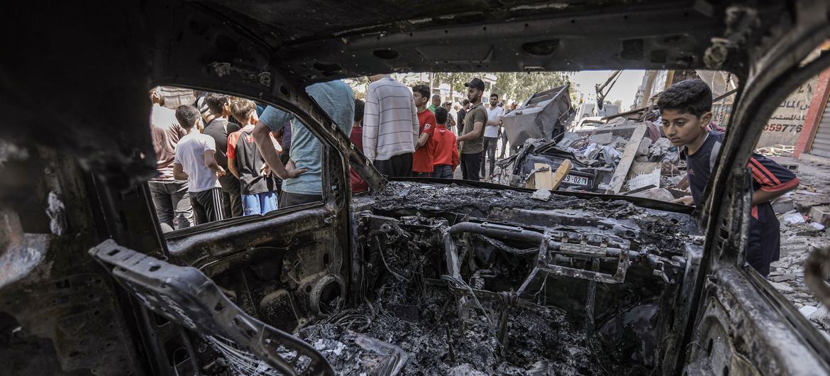 A young boy looks at a burnt vehicle after an Israeli airstrike in the Gaza Strip in 2022.