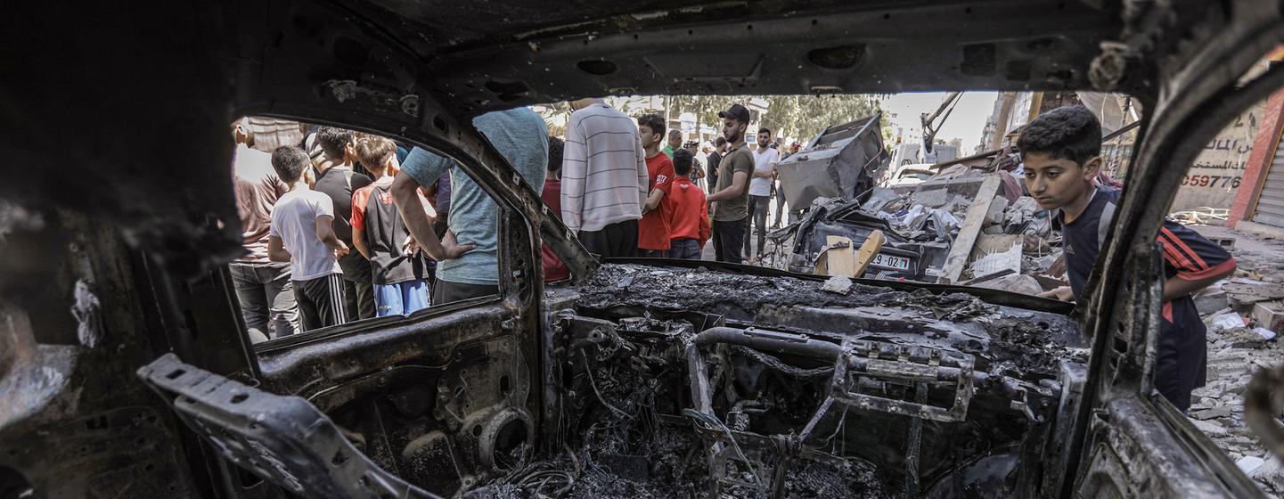 Un jeune garçon regarde un véhicule incendié après une frappe aérienne israélienne dans la bande de Gaza en 2022.
