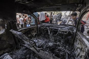 A young boy looks at a burnt vehicle after an Israeli airstrike in the Gaza Strip in 2022.