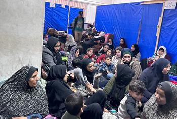 妇女和儿童在加沙汗尤尼斯的近东救济工程处一处人满为患的设施中避难，附近传来枪声和炮击声。