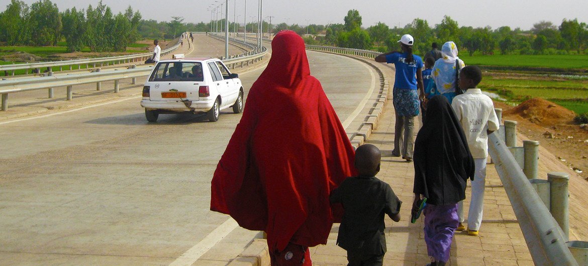 Une famille marche au bord d'une route à Niamey, au Niger.