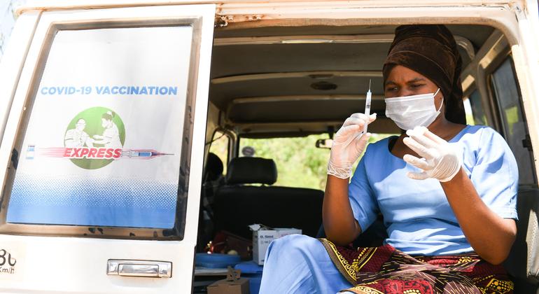 मलावी में एक स्वास्थ्यकर्मी, कोविड-19 वैक्सीन का टीका लगाने की तैयारी करते हुए.