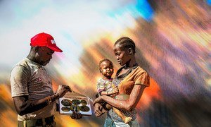 An UN Mine Action Service (UNMAS) community liaison officer, talks to a woman in South Sudan about the danger of mines.