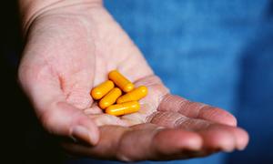 A file photo of a person with capsules in their hand.