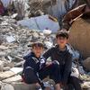طفلان فلسطينيان يجلسان بين أنقاض المباني المدمرة في مخيم جباليا، شمال قطاع غزة