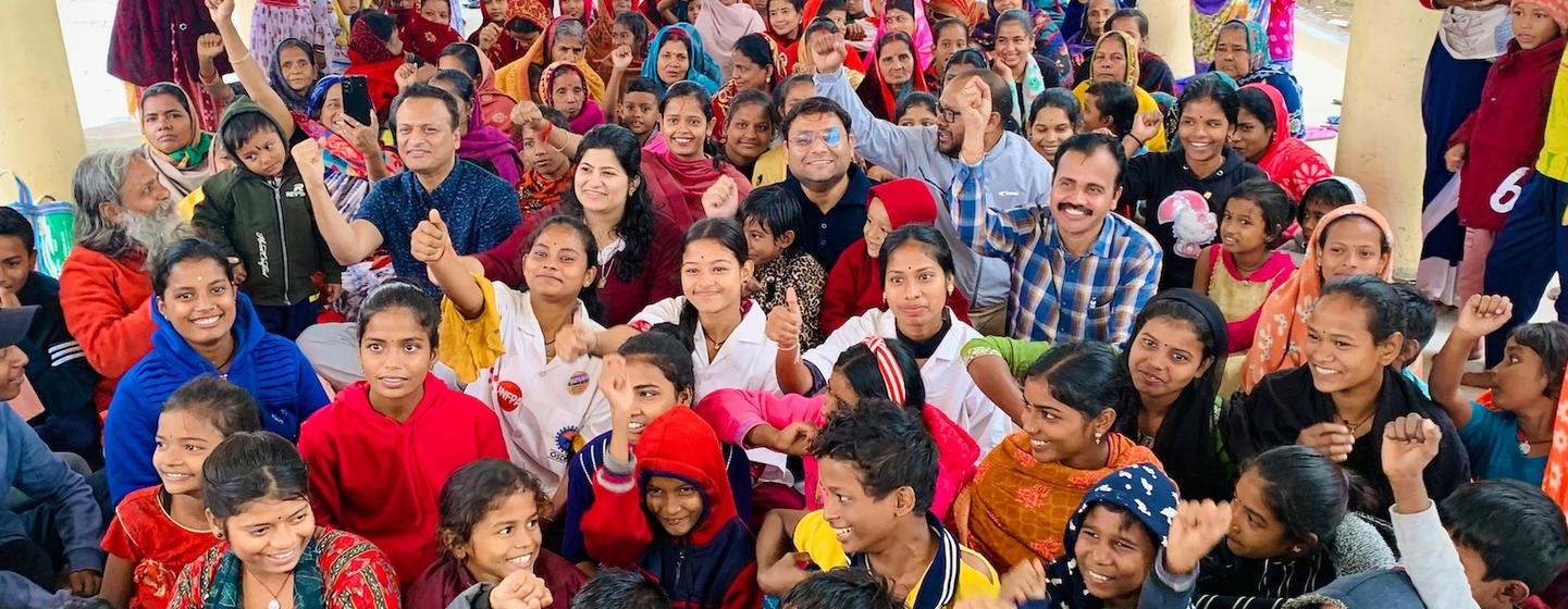भारत में यूनेस्को-आईओसी द्वारा आयोजित सुनामी रेडी प्रोग्राम कार्यक्रम में बच्चों और वयस्कों सहित लोगों का एक बड़ा समूह भाग ले रहा है और एक समूह तस्वीर के लिए पोज दे रहा है।