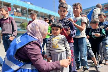 El personal de UNRWA ayuda a los niños de Gaza.