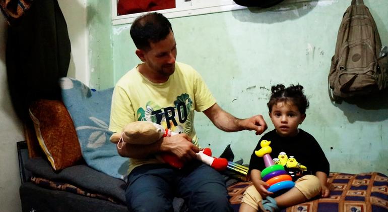 باسم الحبل، صانع محتوى فلسطيني من ذوي الإعاقة يعاني من الصمم نزح من شمال غزة إلى دير البلح، مع طفلته.