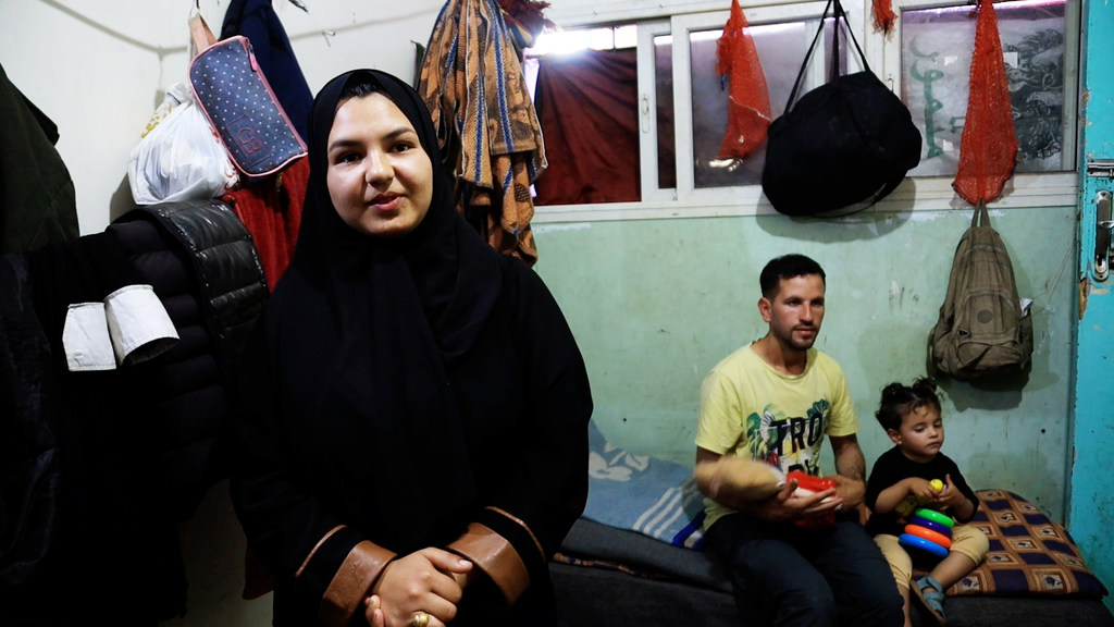 غالية الكيلاني، نازحة فلسطينية من شمال غزة إلى دير البلح، تساعد زوج شقيقتها باسم الحبل في ترجمة لغة الإشارة.