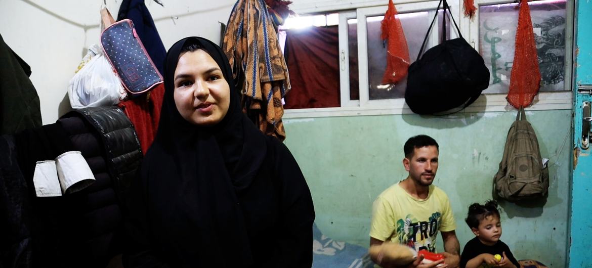 Ghalia Al-Kilani, with her brother-in-law Bassem Al-Habal and her niece in the background, in a shelter for displaced people in Deir Al-Balah, Gaza.