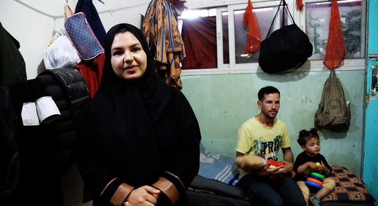 Ghalia Al-Kilani, con su cuñado Bassem Al-Habal y su sobrina al fondo, en un refugio para desplazados en Deir Al-Balah, Gaza.