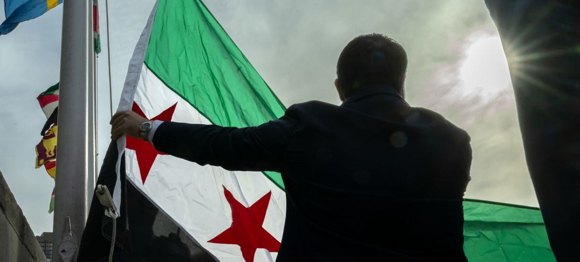 Foreign Miniser Asaad Al-Shaibani of the Syrian Arab Republic, raises the new flag of the country at the UN Headquarters in New York. Foreign Miniser Asaad Al-Shaibani of the Syrian Arab Republic, raises the new flag of the country at the UN Headquarters in New York.