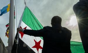 El ministro de Asuntos Exteriores interino de la República Árabe Siria, Asaad Al-Shaibani, iza la nueva bandera del país en la sede de la ONU en Nueva York.