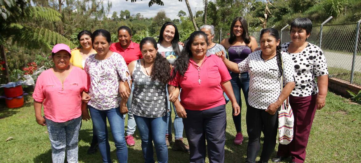 Um grupo de mulheres do coletivo de produção de café 50 Amigas posa para uma foto ao ar livre em Caucas, Colômbia.
