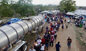 Exhausted migrants take the last steps out of the Darien jungle and into a community.