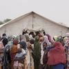Refugiados sudaneses esperam na fila para receber comida em Adre, perto da fronteira do Chade com o Sudão