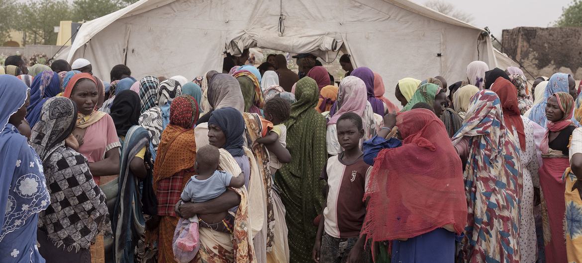 Refugiados sudaneses esperam na fila para receber comida em Adre, perto da fronteira do Chade com o Sudão