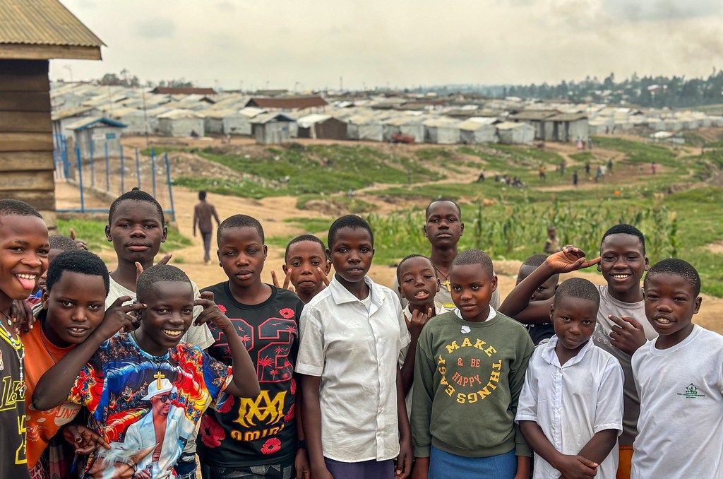 Les élèves de l'école primaire Saint-Luc, située dans le site de déplacés de Kigonze, à Bunia (RDC), suivent des cours par radio dans le cadre du programme Bana Education.