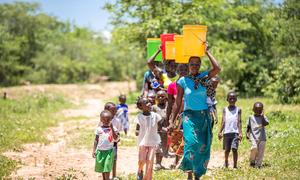 Women and children  collect water from a recently rehabilitated well point in Gwembe Valley, Zambia. (file)