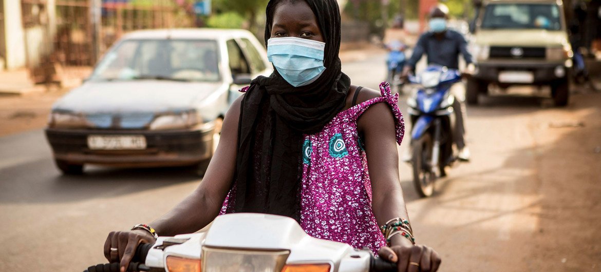 A woman rides a moped in during the COVID-19 pandemic in Mali.