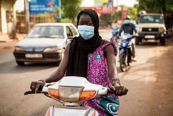 A woman rides a moped in during the COVID-19 pandemic in Mali.