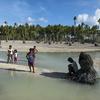 Children in a Pacific Island stand in an area heavily affected by sea level rise and coastal erosion. 