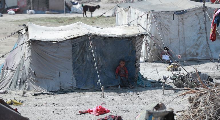 在叙利亚东北部拉卡市的一个非正式定居点，一名儿童站在他的临时住所外。