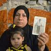 A woman in Iraq displays a photograph of her husband who disappeared more than 30 years ago.