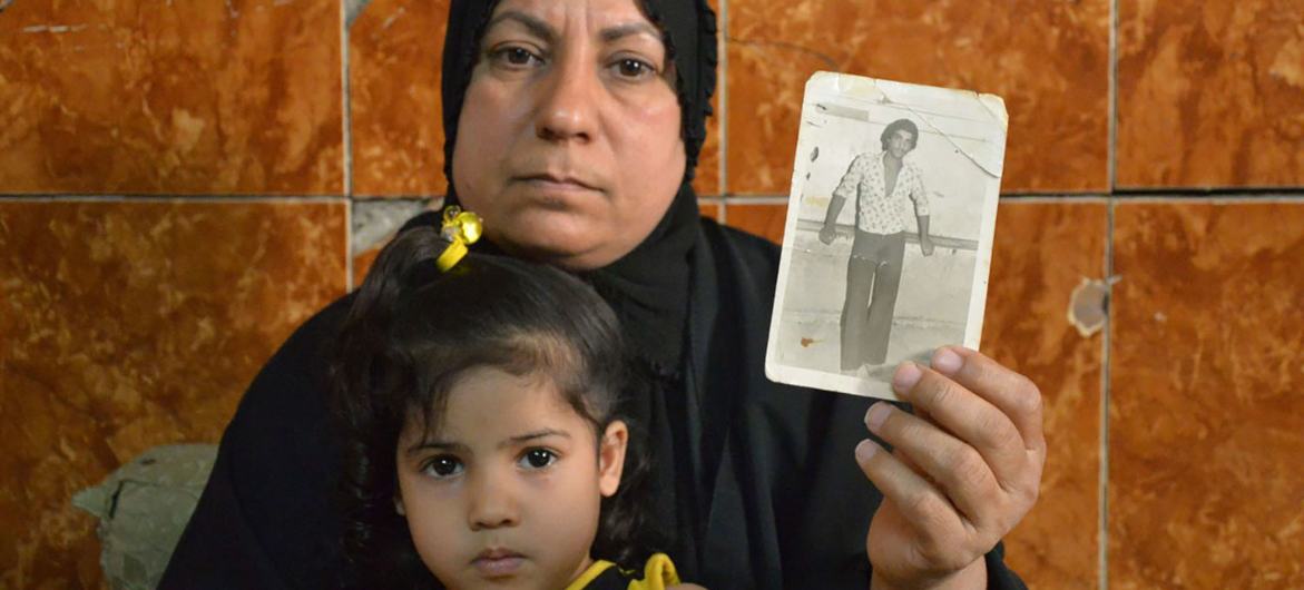 En Iraq, une femme montre une photo de son mari disparu il y a plus de 30 ans.