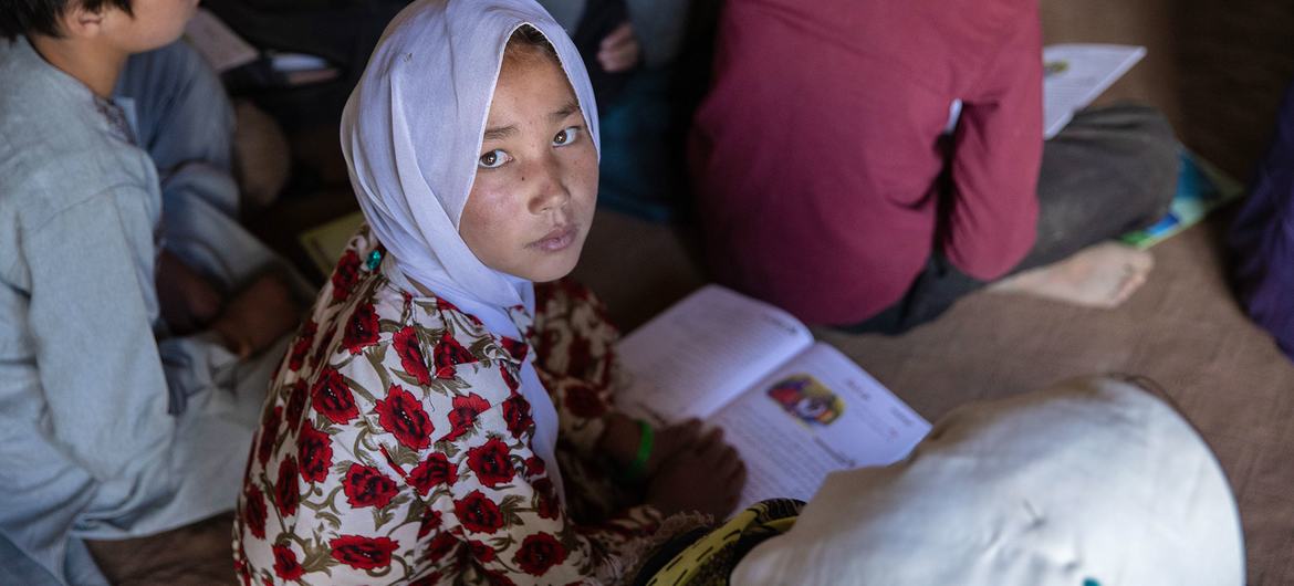 在阿富汗的巴米扬省，一名女孩在社区教育课堂上读书，因为最近的公立学校要步行两个多小时才能到。