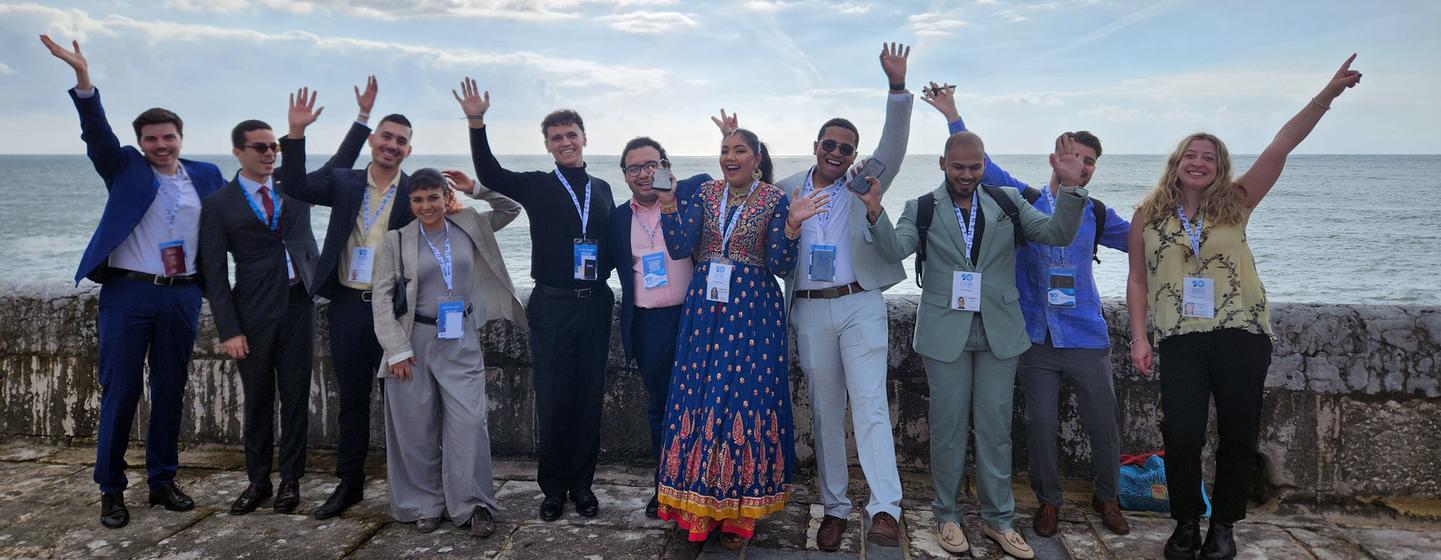 Un groupe de jeunes participants divers au Forum de la jeunesse de l'Alliance des civilisations des Nations Unies à Cascais, au Portugal, qui a fait signe et souriant à la mer le 25 novembre 2024.