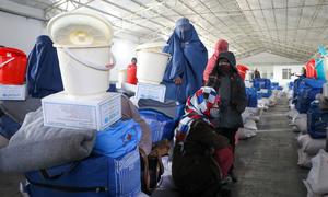 Mulheres e suas filhas recebem kits de invernização do UNICEF no Afeganistão. O kit inclui farinha, arroz, cobertores, roupas quentes, lona e baldes de água.