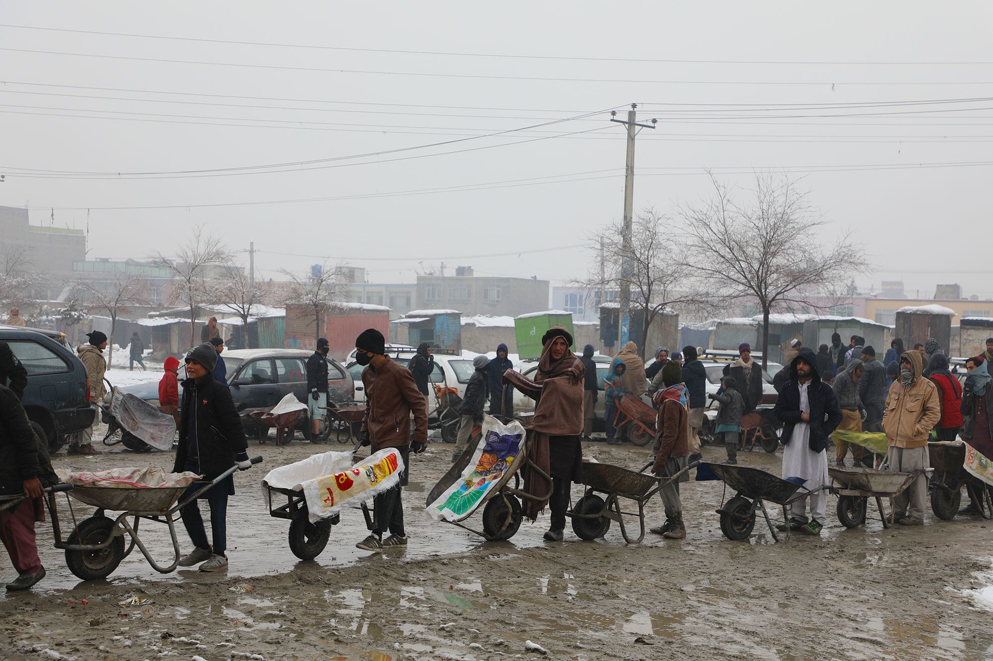 人们在阿富汗首都喀布尔排队等候粮食署的粮食援助。 