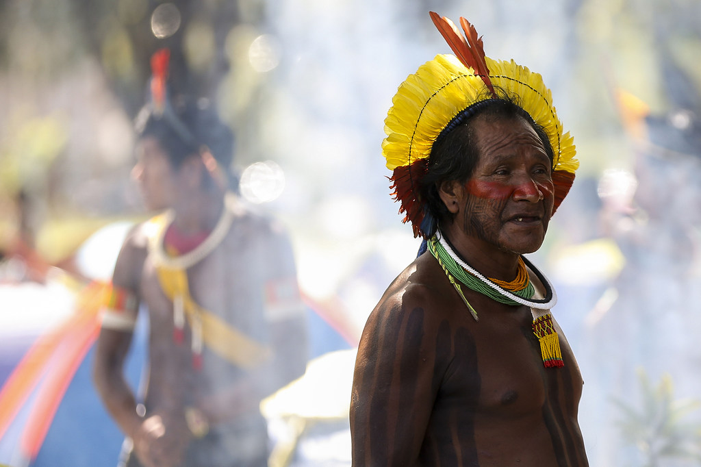 Un hombre indígena yanomami con atuendo ceremonial tradicional, que incluye un tocado de plumas y pintura corporal, en el campamento Terra Livre en Brasilia.