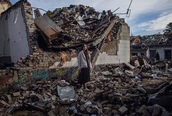 A Ukrainian teenager stands in the rubble of her destroyed school in Zhytomyr.