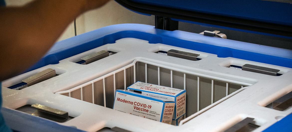 Boxes of Moderna COVID-19 vaccine sit in a white basket inside an open blue UNICEF solar-powered refrigerator at Saint-Damien Hospital in Port-au-Prince, Haiti.