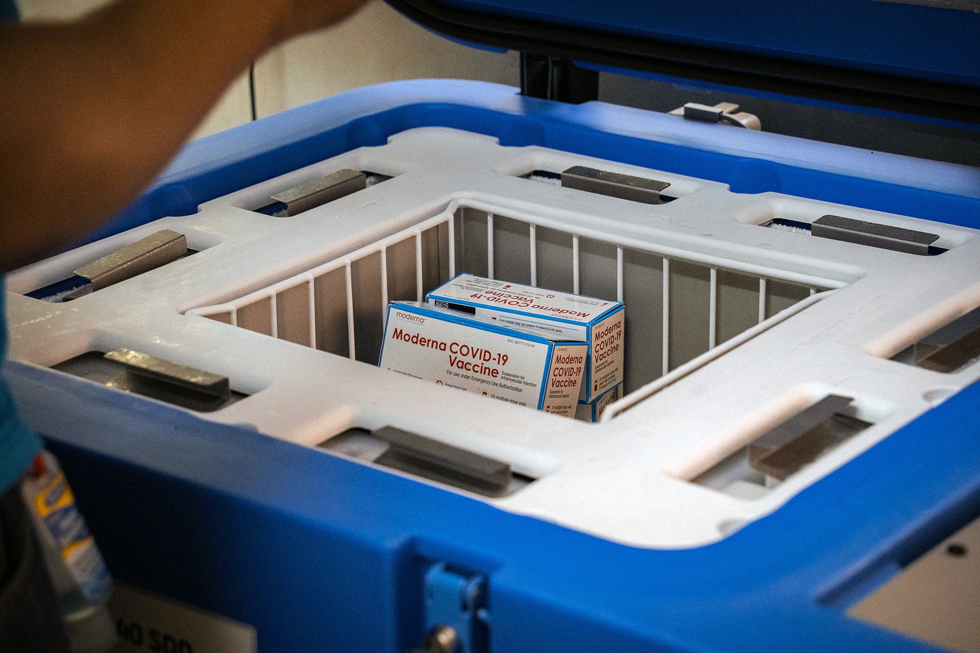 En el hospital Saint-Damien de Puerto Príncipe, Haití, se pueden ver cajas de la vacuna Moderna contra la COVID-19 en una cesta blanca dentro de un frigorífico azul abierto de UNICEF que funciona con energía solar.