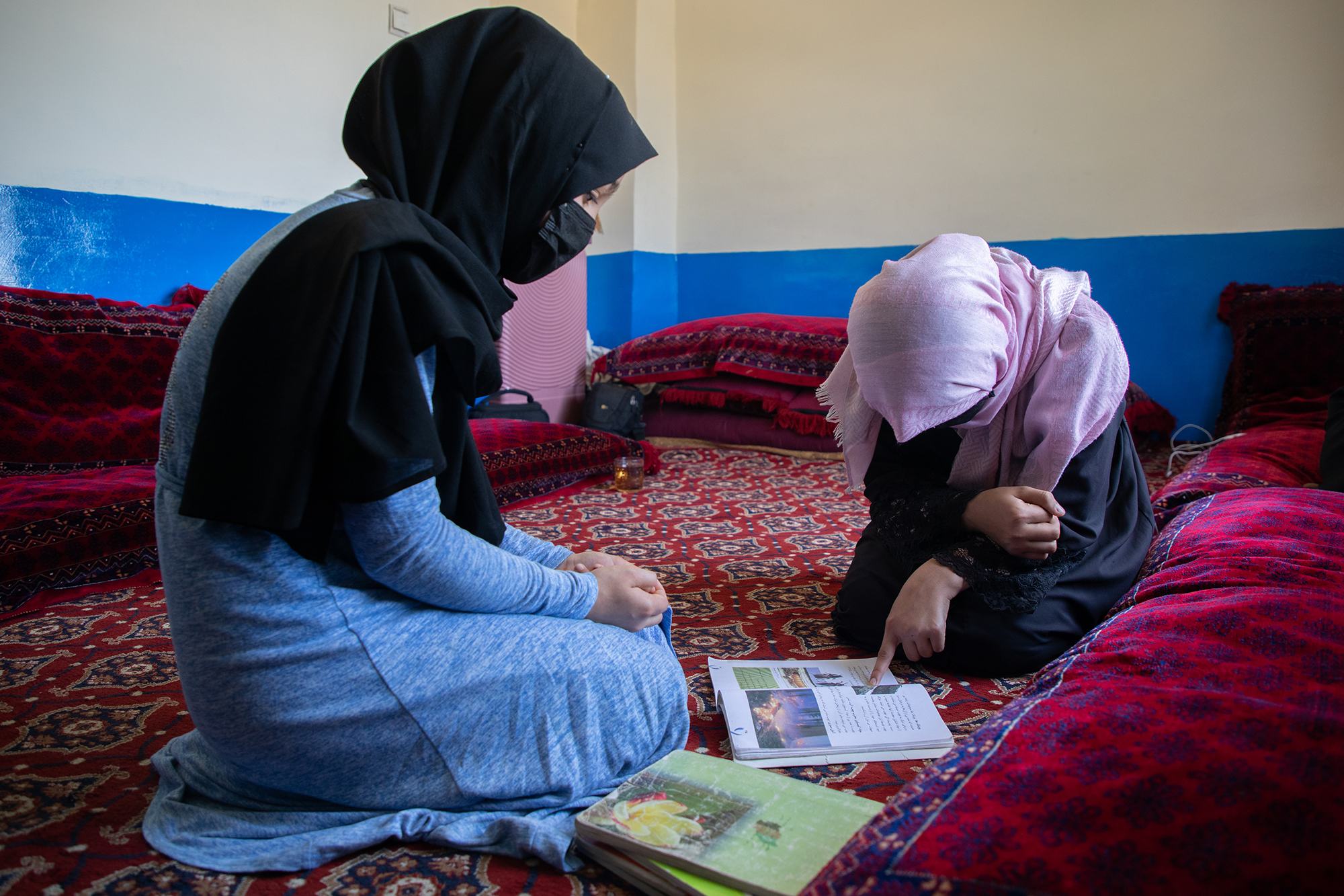 En juin 2024, Sharifa (à droite), 15 ans, aide sa jeune sœur Madina, 13 ans (à gauche) à étudier. Toutes deux étaient déscolarisées depuis près de trois ans.