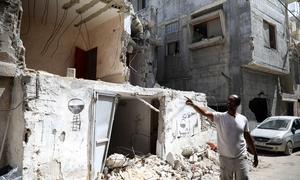 A resident of the Tulkarm refugee camp in the West Bank shows damage to a building. (April 2024)