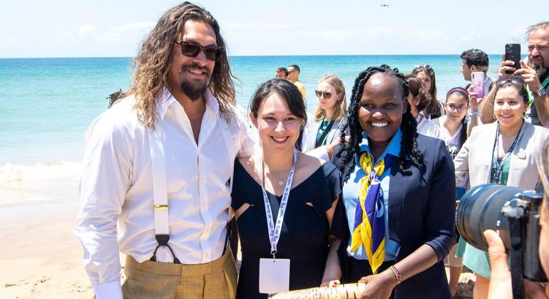 在联合国海洋大会期间，演员兼海洋活动家杰森·莫玛（Jason Momoa）（左）在葡萄牙里斯本的海滩会见青年倡导者。