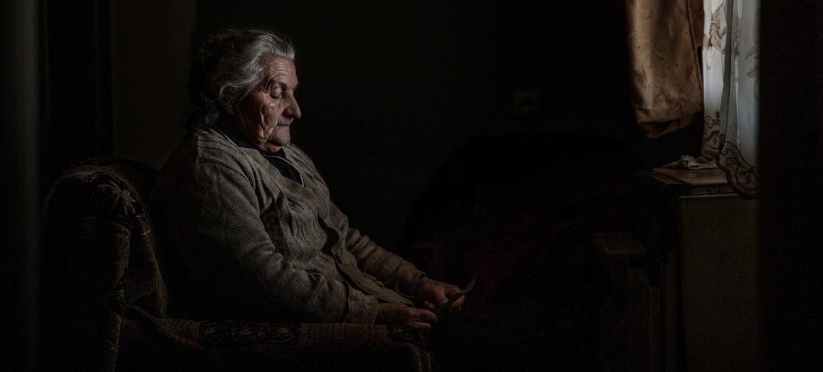 Elene olha para uma fotografia de sua antiga casa na Ossétia do Sul. Ela vive em um campo de deslocados em Karaleti, Geórgia, desde que foi deslocada pelos conflitos em 2008