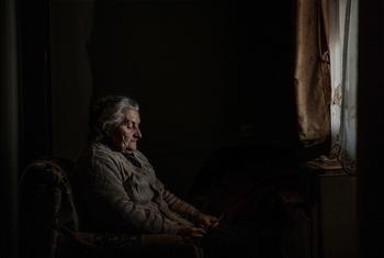 Elene olha para uma fotografia de sua antiga casa na Ossétia do Sul. Ela vive em um campo de deslocados em Karaleti, Geórgia, desde que foi deslocada pelos conflitos em 2008