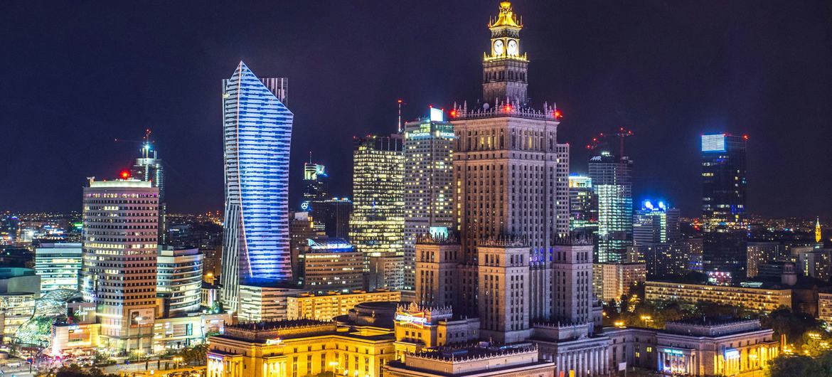 A panoramic view of high-rise buildings at night time in the city Warsaw, Poland.