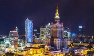 A panoramic view of high-rise buildings at night time in the city Warsaw, Poland.