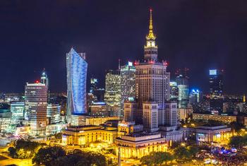 A panoramic view of high-rise buildings at night time in the city Warsaw, Poland.